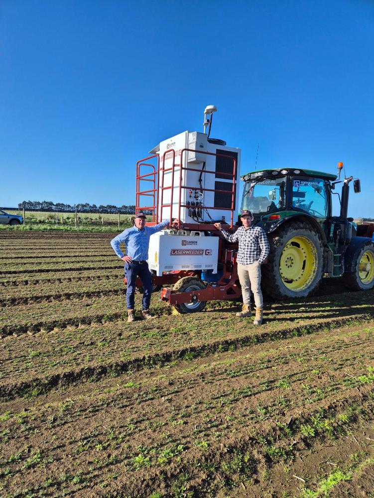Jesse and Matthew Malcolm standing beside the G2-200 Laser Weeder on the So Sweet farm.