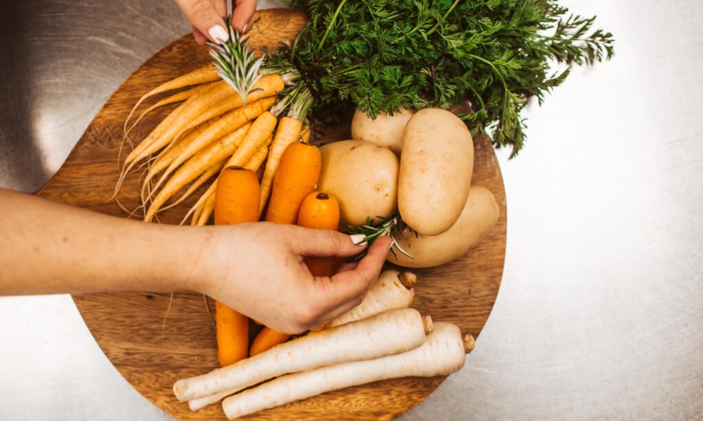 A selection of fresh Southland-grown carrots, parsnips and potatoes on a wooden board, prepared for cooking