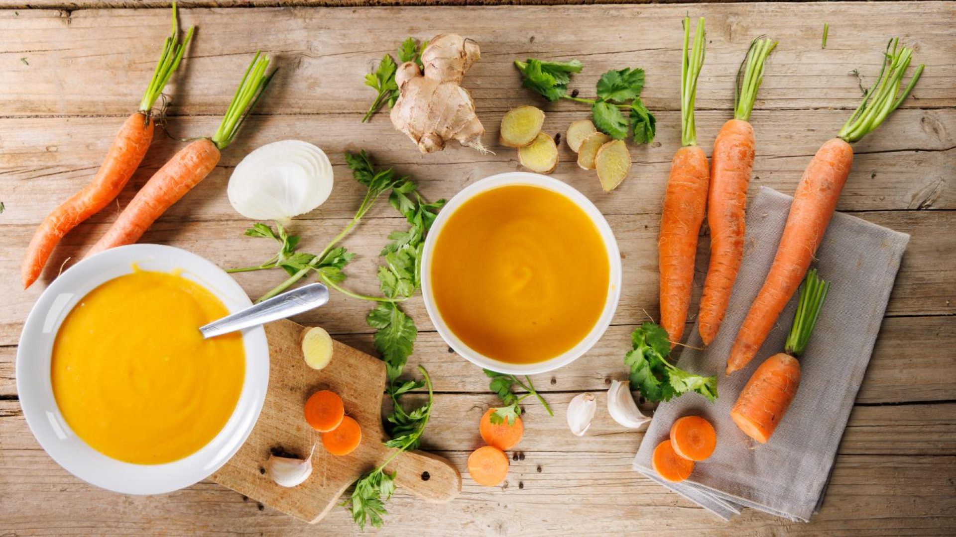 Carrots simmering in a pot with onion, garlic, and ginger for a carrot soup recipe