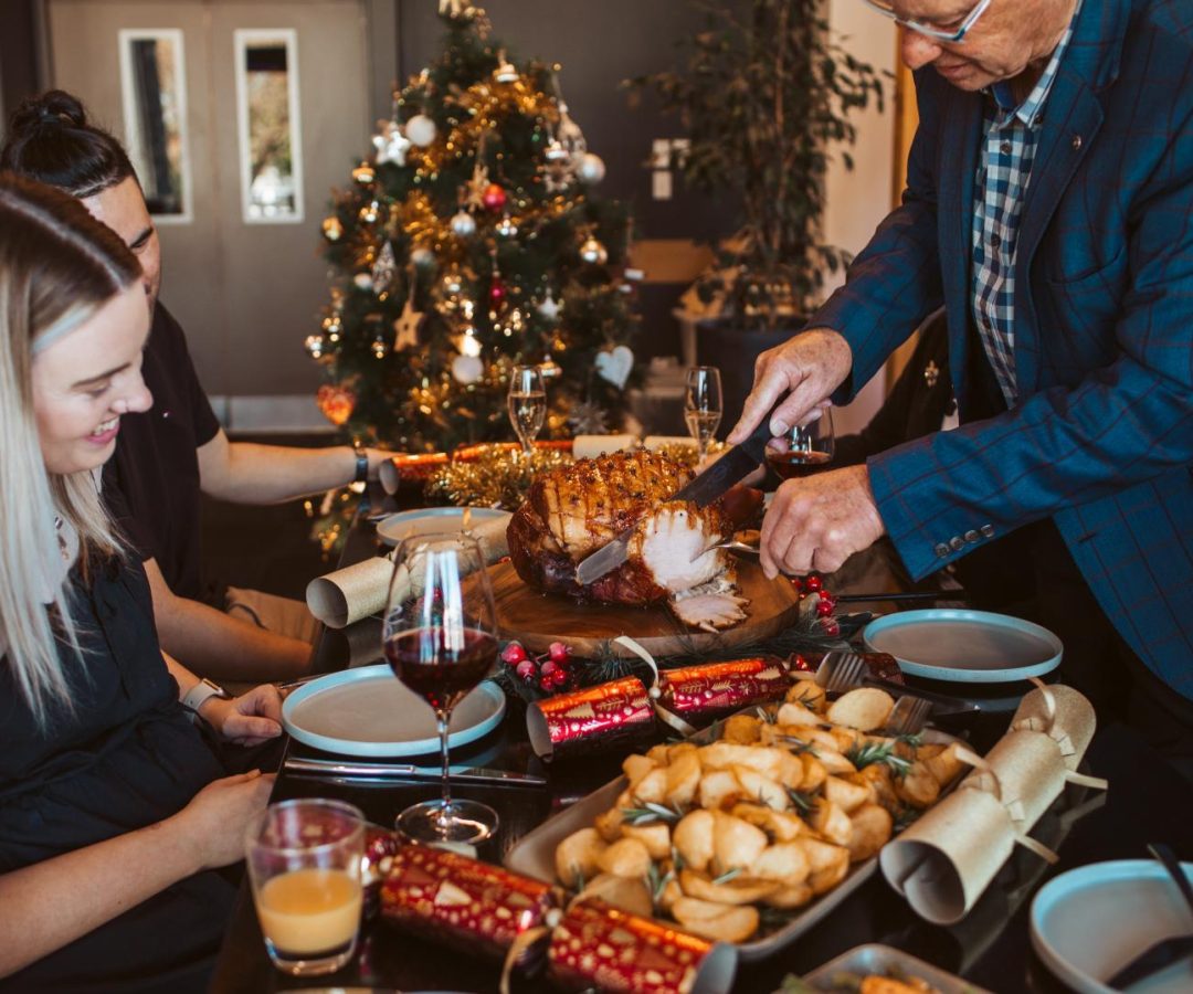 Family enjoying a Christmas meal with roasted vegetables, supporting the theme of Christmas celebration vegetable gift boxes.