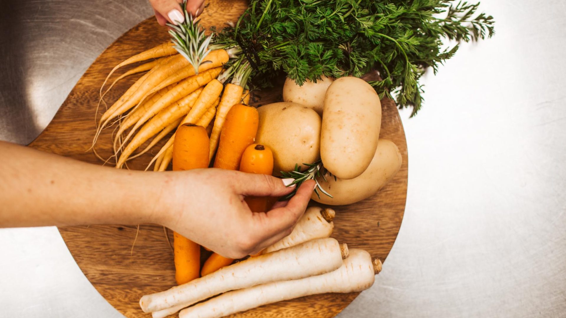 A selection of fresh Southland-grown carrots, parsnips and potatoes on a wooden board, prepared for cooking